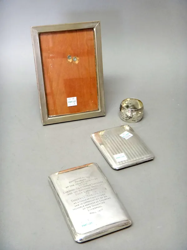 A silver rectangular cigarette case, presentation inscribed, Birmingham 1915, silver napkin ring with pierced decoration, Birmingham 1921, a rectangul