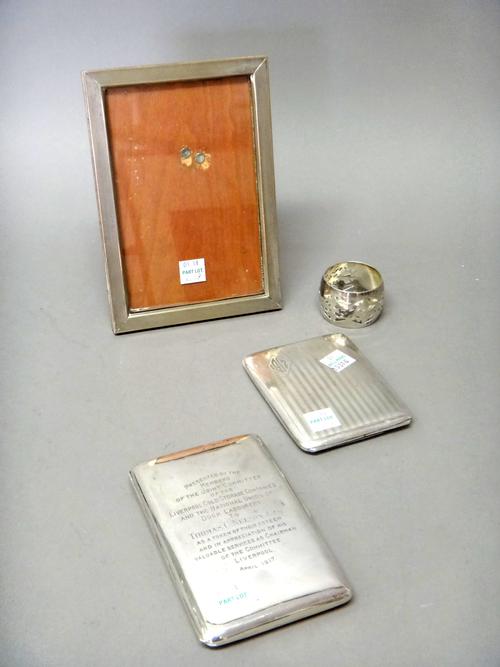 A silver rectangular cigarette case, presentation inscribed, Birmingham 1915, silver napkin ring with pierced decoration, Birmingham 1921, a rectangul