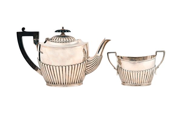 A late Victorian silver teapot with a matching silver twin handled sugar bowl, each piece of oval form with partly fluted decoration, the teapot with