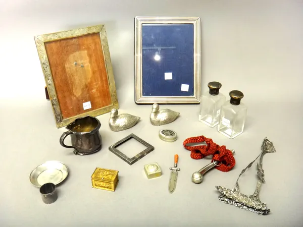 Silver mounted wares, comprising; a rectangular photograph frame, having a reeded border, two mounts from a frame, a christening mug, a cylindrical fi