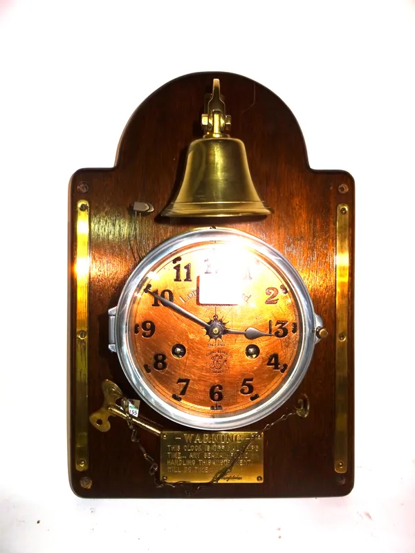 A 20th century 8 day brass porthole clock, 'Lord Kelvin Ltd', mounted on mahogany board with brass belt. E5