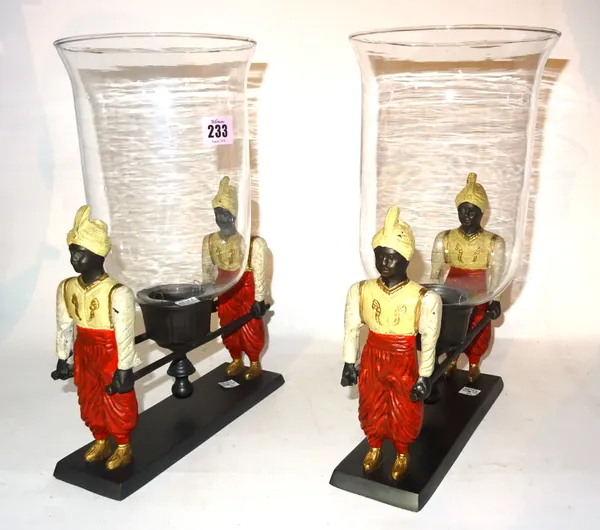 A pair of 20th century cast iron and glass hurricane lamps each formed as a pair of Blackamoor figures carrying sedan poles, 36cm high, (2).   S2T
