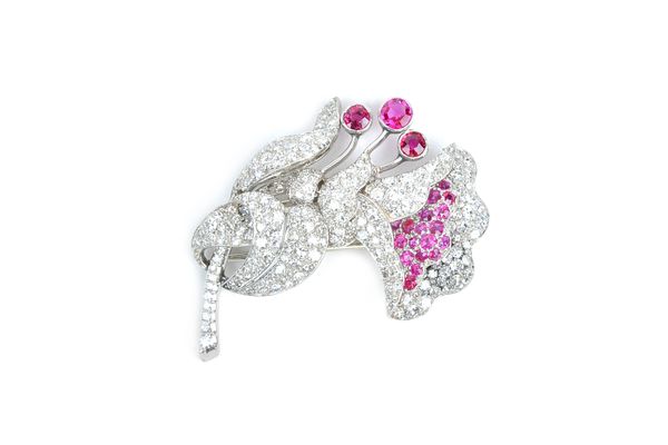 A ruby and diamond clip brooch, in a floral spray design, circa 1940, mounted with three principal circular cut rubies, further smaller circular cut r