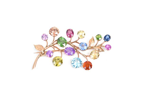 A gold and vary coloured gemstone set brooch, designed as a foliate spray, the gemstones including amethyst, pale brown zircon and sapphire, length 6.