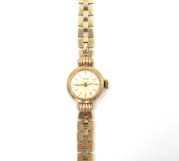 A Tissot 9ct gold lady's bracelet wristwatch, the signed circular silvered dial with gilt baton shaped numerals, on a three tier brick link bracelet,