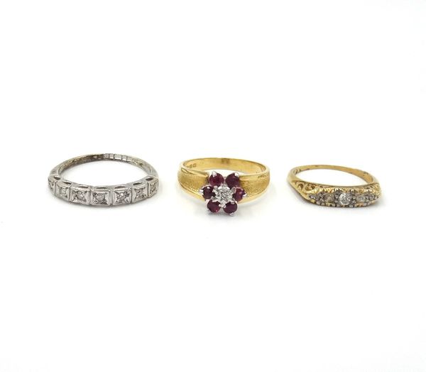 A gold and diamond set five stone ring, mounted with a row of cushion shaped diamonds, an 18ct gold, ruby and diamond set seven stone cluster ring, ha