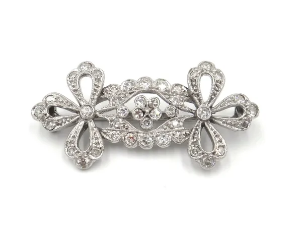 A diamond brooch, in a pierced panel shaped design, with bow terminals, mounted with circular cut diamonds.