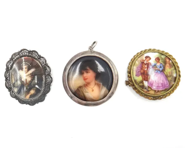 A silver mounted ceramic miniature circular pendant, designed as the portrait of a girl, wearing a necklace, London 1905, a circular ceramic brooch, d