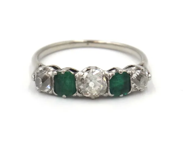 An emerald and diamond five stone ring, mounted with three cushion shaped diamonds, alternating with two square cut emeralds, ring size N.