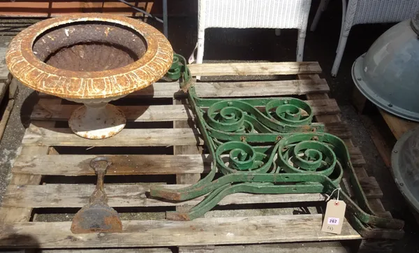 An early white painted cast iron urn, 55cm wide x 38cm high, a pair of green strapwork bench ends and a cast iron door stop formed as a bell, 30cm hig