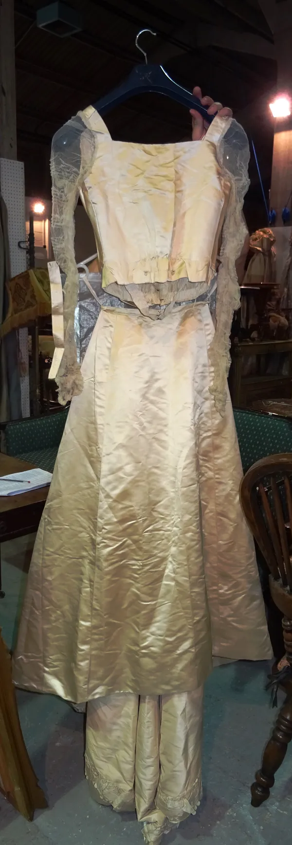 An Edwardian two piece wedding dress, comprising a cream silk long skirt with train, a bodice top with lace long sleeves, gloves, stockings and extra