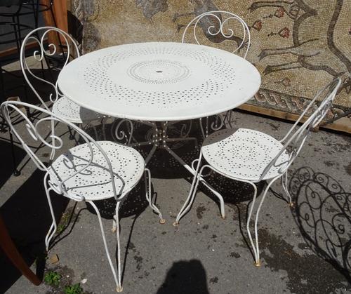A 20th century French white painted metal circular wire work garden table with four matching chairs, 103cm wide x 76cm high (5). OUT