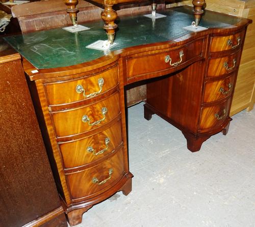 A 20th century mahogany double serpentine writing desk with green leather inset top, 105cm wide x 76cm high.   H8