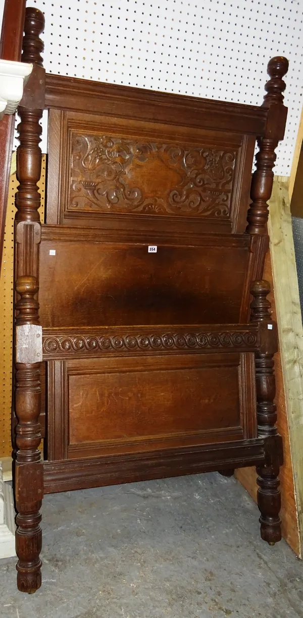 An early 20th century oak single bed with carved headboard on ring turned block supports, 92cm wide x 164cm high.  EXTRA