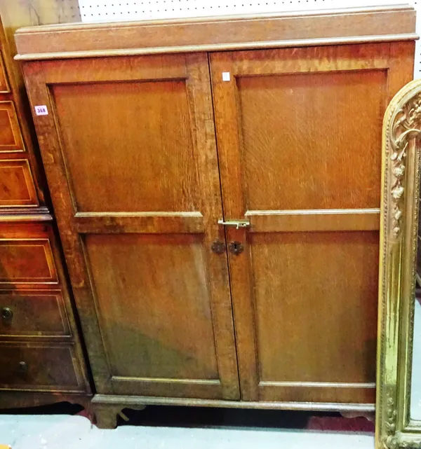 An early 20th century oak two door cabinet, on bracket feet, 95cm wide.   B10