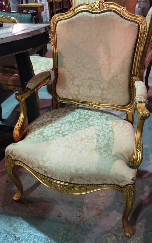 A pair of Louis XV style gilt framed open armchairs with serpentine seat and scroll supports, 65cm wide x 96cm high (2).  E4
