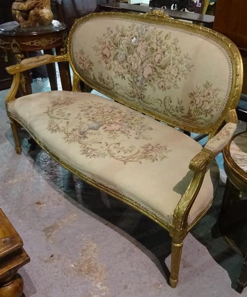 A Louis XVI style gilt framed open arm sofa on tapering fluted supports, 140cm wide x 95cm high.  G4