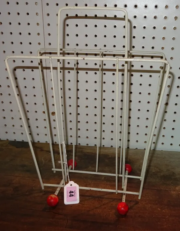 A 1950s Atomic Sputnik magazine rack, white steel frame and red wooden ball feet, 30cm wide.   A6