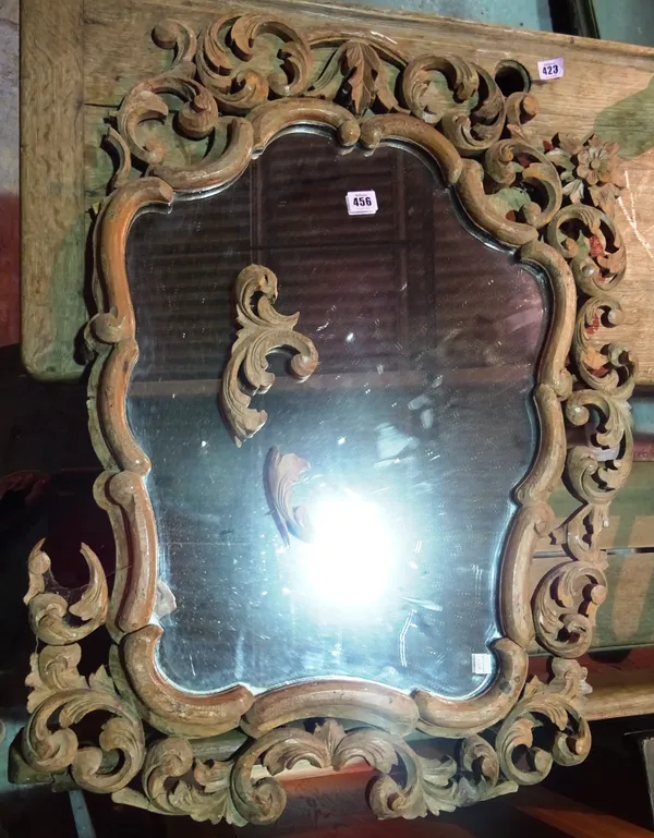 A 19th century North Italian mirror, the shaped plate within a pierced and foliate softwood frame, 60cm wide x 85cm high. Provenance; Property from Pr
