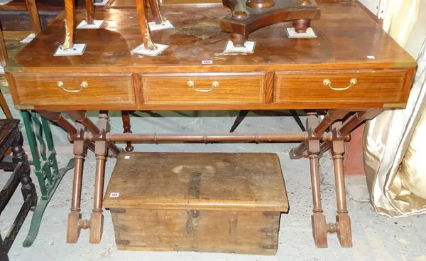An Anglo-Indian brass bound teak three drawer writing table on dual X frame supports, 122cm wide x 79cm high.   H5