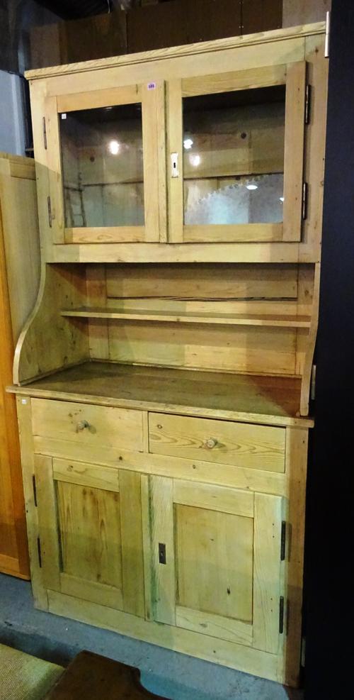 A 20th century Swiss pine dresser with two drawers over cupboard base and a two glass door fronted cabinet top, 112cm wide x 226cm high.  M7