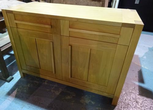 A 20th century oak side cabinet with two drawers over cupboard base on block supports, 123cm wide x 90cm high.  H9