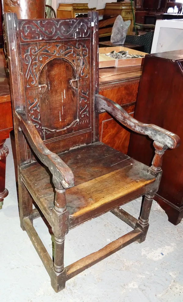 A 17th century and later oak carved panel back Wainscot chair, on turned supports united by perimeter stretcher, 63cm wide x 116cm high. Provenance; P