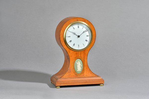 A French satinwood balloon shaped mantel clock, late 19th century, with white enamel dial over a waisted case, inset with a Wedgwood style oval porcel