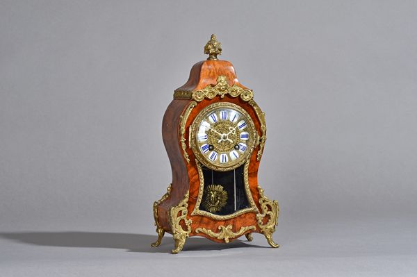 A French Louis XVI style walnut cased mantel clock, circa 1900, with waisted cased and gilt metal foliate embellishments, enamel Roman numerals over a