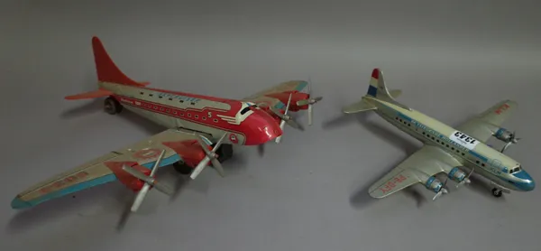An Arnold tinplate 'Flying Duchman' aeroplane, 32cm wide, another similar, a Japanese North West Airlines (NWA) passenger aeroplane, 26cm wide, a Marx
