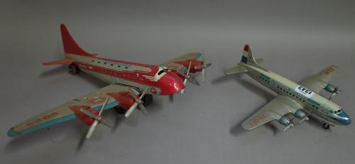 An Arnold tinplate 'Flying Duchman' aeroplane, 32cm wide, another similar, a Japanese North West Airlines (NWA) passenger aeroplane, 26cm wide, a Marx