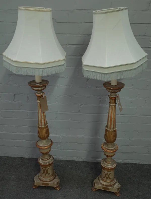 A pair of 18th century style Italian giltwood altar candlesticks, modern, of turned, carved and distressed form on three shaped feet, 86cm high, with