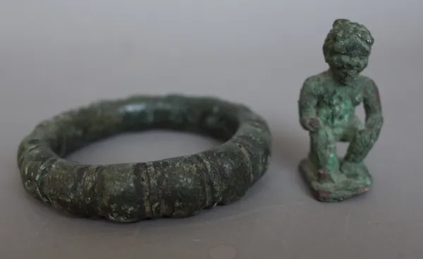 Antiquities; a verdigris iron bangle of circular form and a small metal figure, 5cm high, (2).