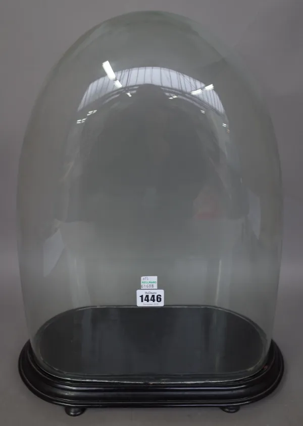 A Victorian glass display dome on an ebonised oval wooden stand and four wooden feet, 47.5cm high overall.
