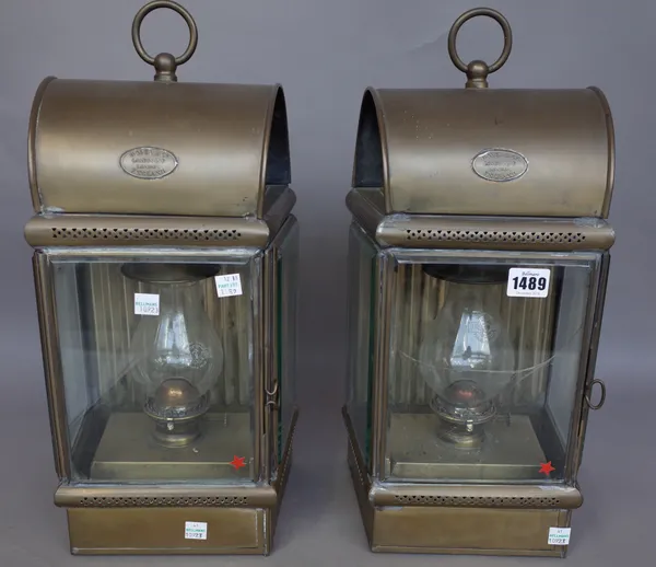 A pair of patinated metal wall mounted oil lamps/lights by Davey & Co, London, each with ring handle, arch roof and bevelled glass panels, 45cm high,