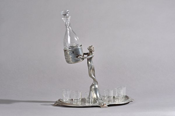 A WMF pewter figural Art Nouveau liqueur stand with glasses stamped maker's marks, circa 1900, 35cm high overall. Illustrated.