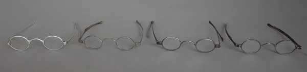 Four pairs of Georgian silver spectacles with oval lenses, early 19th century, maker's stamp on one for Thomas Phelps, no lenses, all four with turn p