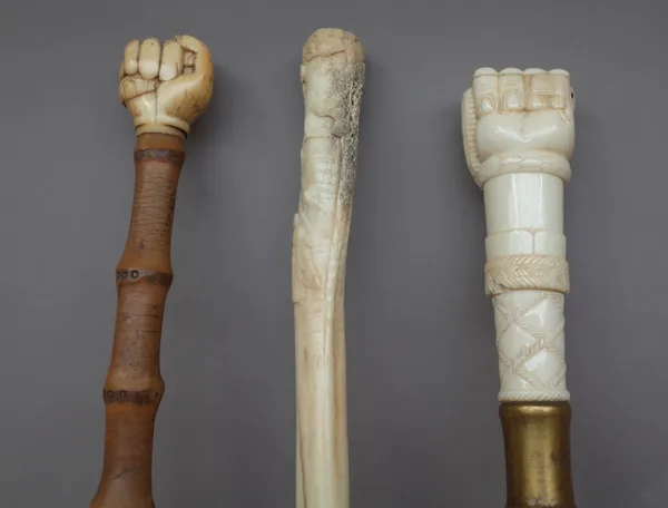 An 18th century and later mounted bamboo walking cane with clenched fist pommel, 80cm, a marine ivory walking cane pommel, 19th century, with clenched