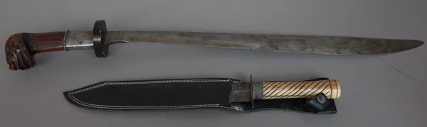 A Malaysian Parang, late 19th century with curved steel blade, 47cm, circular wooden hilt and an ornately carved wooden handle and a late 19th century
