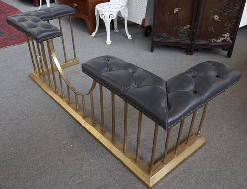 A George III style brass and leather club fender with tubular supports and black leather button back padded corner seats, 172cm wide.