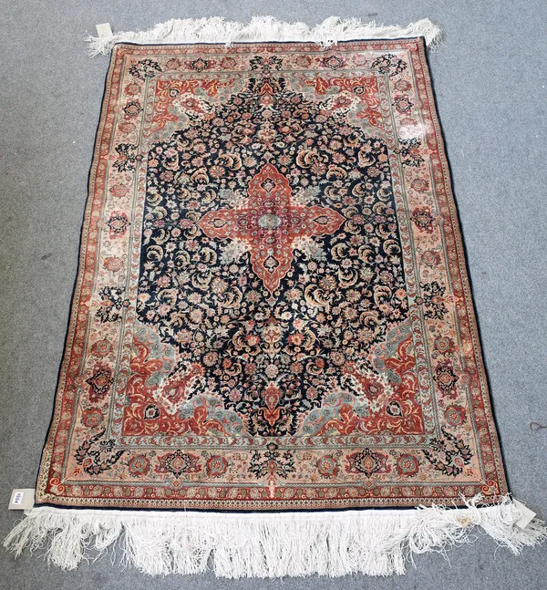 A fine silk Chinese rug, the black field with a madder cross medallion, matching spandrels, all with delicate floral sprays, a pale madder palmette bo