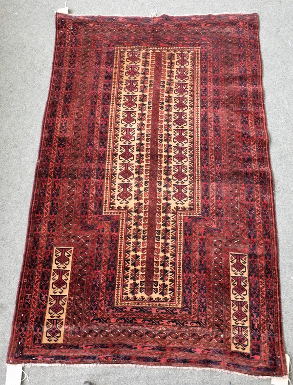 A Beluchistan prayer rug, the camel mehrab with a central stylised plant, supporting hooked motifs, all rising to matching spandrels, nine minor borde