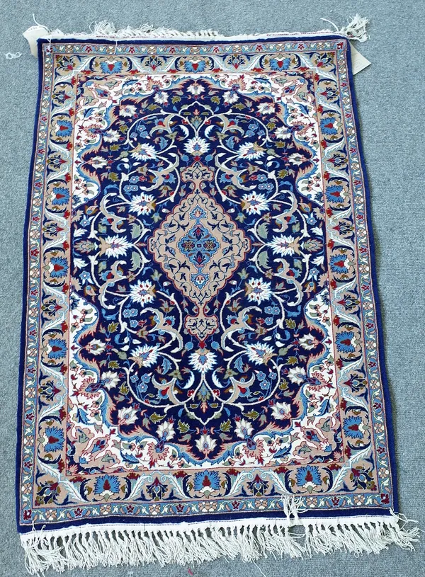 An Esfahan rug, Persian, the indigo field with a brown diamond, floral vines, ivory spandrels; a brown palmette and leaf border, 110cm x 72cm.