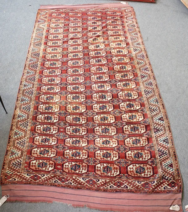 A Kizyl Ayak Turkeman carpet, the madder field with four columns of nineteen guls, a waved hooked ribbon border, 374cm x 202cm.