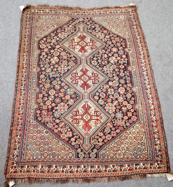 A Ghasghai rug, South Persian, the dark indigo field with three joined ivory cross filled diamonds, all with minor motifs, goats and birds, ivory flow