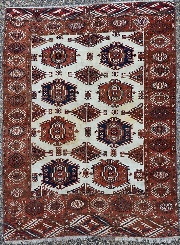 A Yamut carpet, the ivory field with two columns of bold single 'eagle' guls, supporting hooked diamonds; a madder sunburst border, 216cm x 165cm. Ill