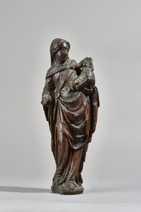 A 17th century carved oak figure of a mother holding her infant, 35cm high, a pair of carved oak columns, 31cm high and a 17th century French steel lo