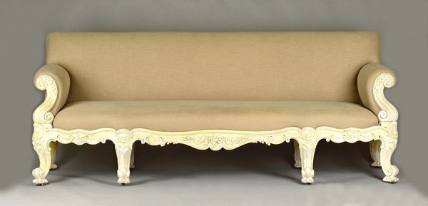 In the manner of Gillows; a large 19th century sofa, with later white painted carved show frame on eight scroll supports, 245cm wide x 95cm high. Illu