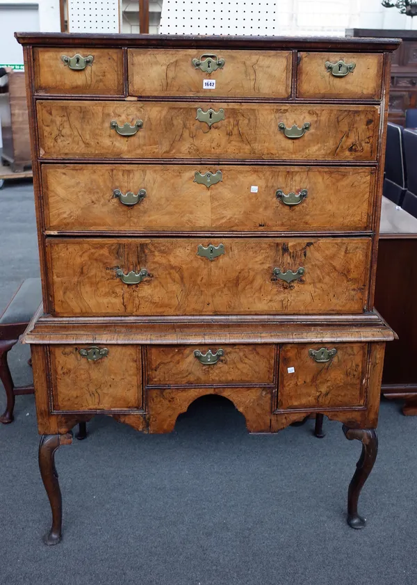A mid-18th century figured walnut chest of three short over three long graduated drawers on associated three drawer stand, 109cm wide x 155cm high.