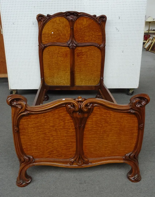Eugene Gaillard (1862-1932); a figured ash and walnut bed frame, the headboard with a four panel back within an organically  carved frame, with matchi